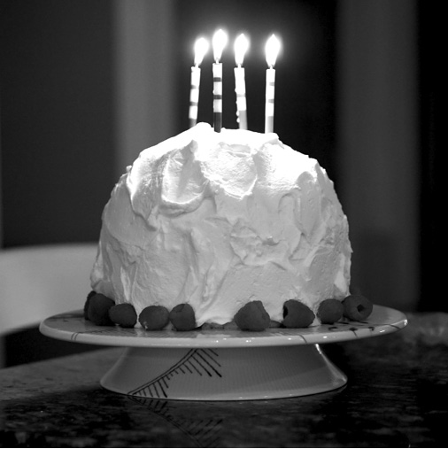Dome-shaped cake covered in whipped cream, with candles