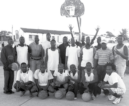 The team posing in front of a basketball hoop